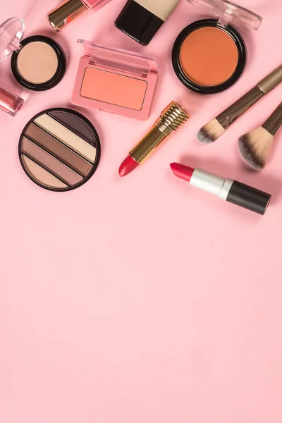 Make-up-Produkte auf rosa Hintergrund von oben. — Stockfoto