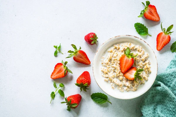 Oatmeal porridge with strawberry on white background. — Stock Photo, Image