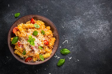 İtalyan makarnası alla arrabiata fesleğen ve parmesan peyniri ile koyu masa..