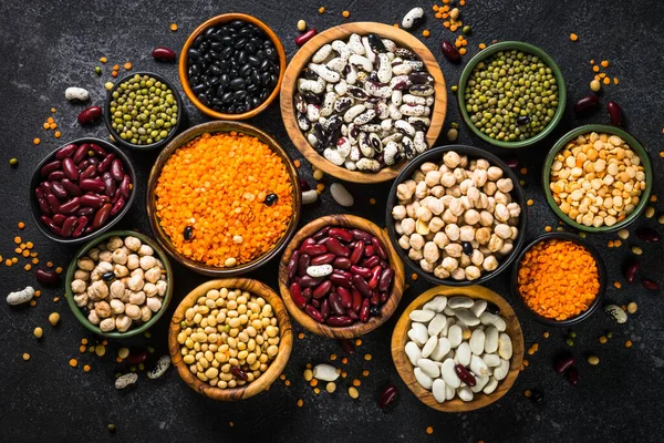 Baklagil, mercimek, bezelye ve fasulye çeşitleri siyah taş masada..