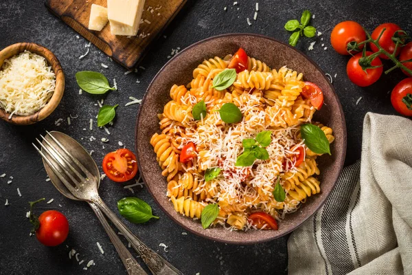 İtalyan makarnası alla arrabiata fesleğen ve parmesan peyniri ile koyu taş masada.. — Stok fotoğraf