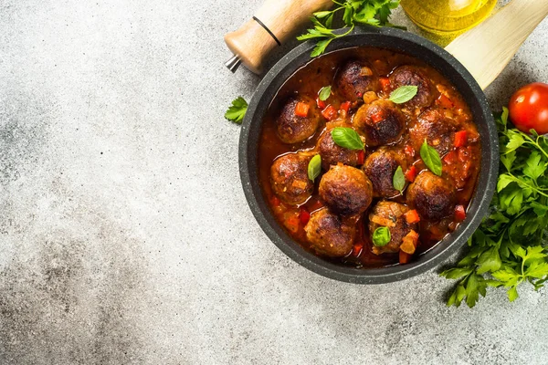Meatballs in tomato sauce in a frying pan on dark stone table. — Stock Photo, Image