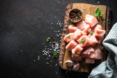 Siyah taş masadaki ahşap tahtada baharatla dilimlenmiş hindi eti.