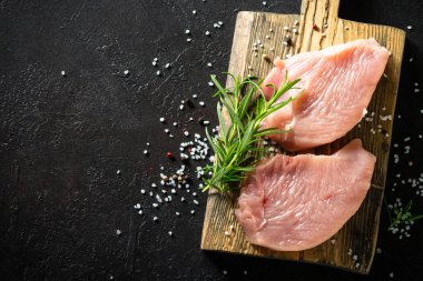 Türkiye, siyah taş masadaki ahşap tahtada baharat ve otlarla biftek yiyor.