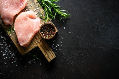 Türkiye, siyah taş masadaki ahşap tahtada baharat ve otlarla biftek yiyor.