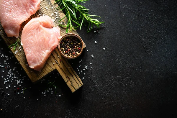 Türkiye, siyah taş masadaki ahşap tahtada baharat ve otlarla biftek yiyor.