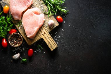 Türkiye, siyah taş masadaki ahşap tahtada baharat ve otlarla biftek yiyor.