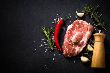 Siyah arka planda baharatlı taze biftek..