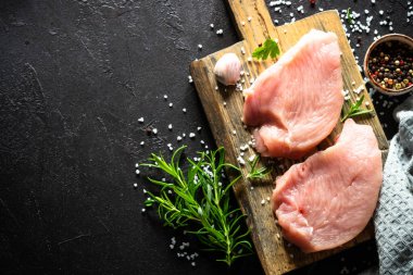 Türkiye, siyah taş masadaki ahşap tahtada baharat ve otlarla biftek yiyor.