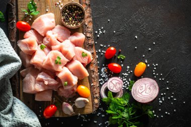 Siyah taş masadaki ahşap tahtada baharatla dilimlenmiş hindi eti.