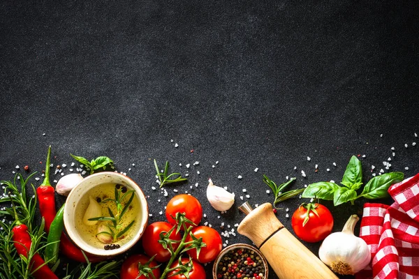 Food background. Fresh vegetables, spices and herbs at black stone table. — Foto de Stock