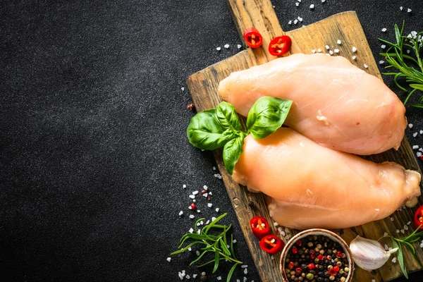 Poitrine de filet de poulet aux épices et légumes à la planche de bois à table noire. — Photo