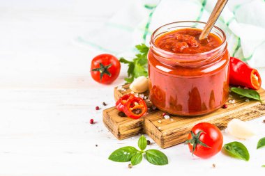 Beyaz arka planda otlu domates sosu ve baharatlar.