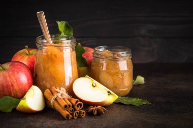 Baharatlı elma reçeli ve koyu arkaplanda taze elma.