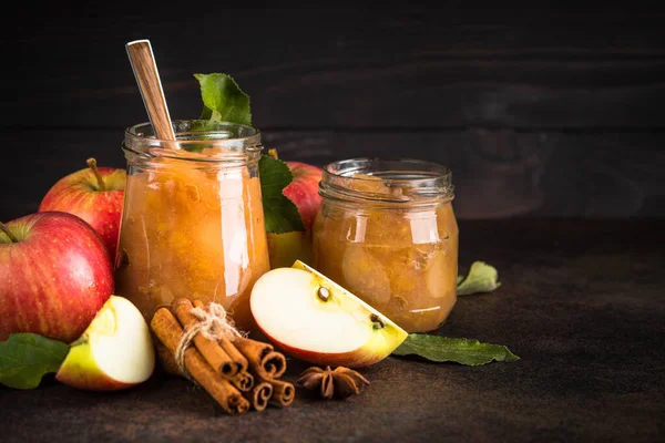 Baharatlı elma reçeli ve koyu arkaplanda taze elma.