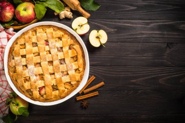 Siyah ahşap masada zencefilli ve tarçınlı elmalı turta. Geleneksel sonbahar pastası. Kopyalama alanı olan en üst görüntü.