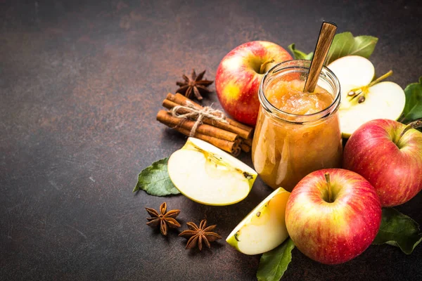 Baharatlı elma reçeli ve koyu arkaplanda taze elma.