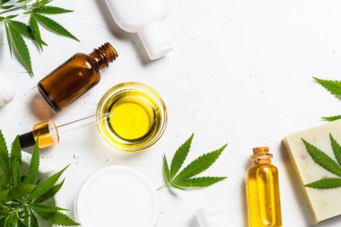 Kenevir yağı, krema, sabun ve beyaz yapraklar.