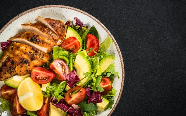 Ahşap masada taze salata ve ızgara tavuk..