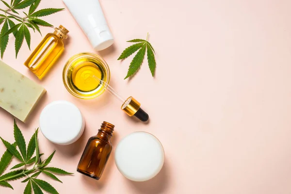 Cannabis oil, cream, soap and fresh leaves at white. — Stock Photo, Image