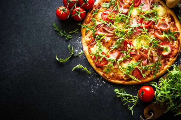 Traditional italian pizza with ham, cheese, tomatoes and arugula. — стокове фото