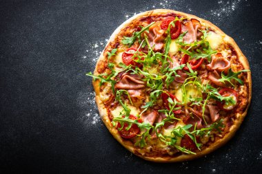 Geleneksel İtalyan pizzası, jambon, peynir, domates ve roka..