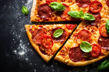 Salam peynirli, domatesli ve fesleğenli geleneksel İtalyan pizzası.
