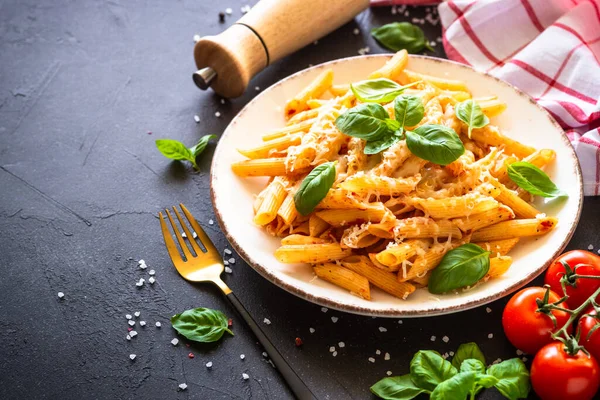 Italian pasta with tomato sauce, basil and parmesan cheese on dark table. — Foto de Stock