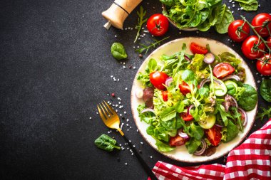 Yeşil salata, taze salata yaprakları ve siyah arka planda sebze..