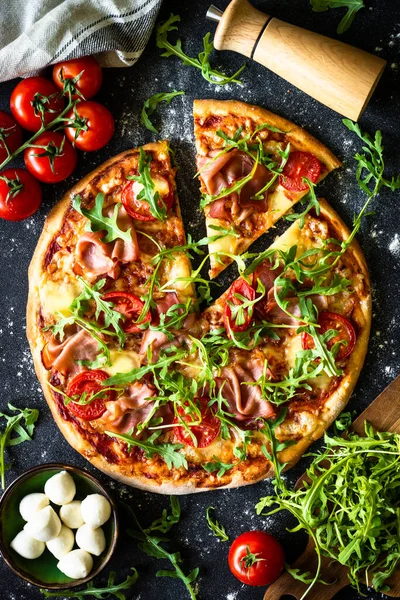 Traditional italian pizza with ham, cheese, tomatoes and arugula. — Foto de Stock