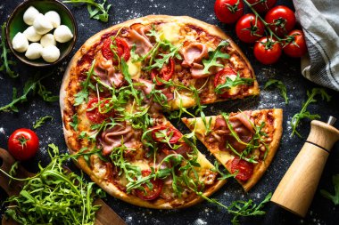 Geleneksel İtalyan pizzası, jambon, peynir, domates ve roka..