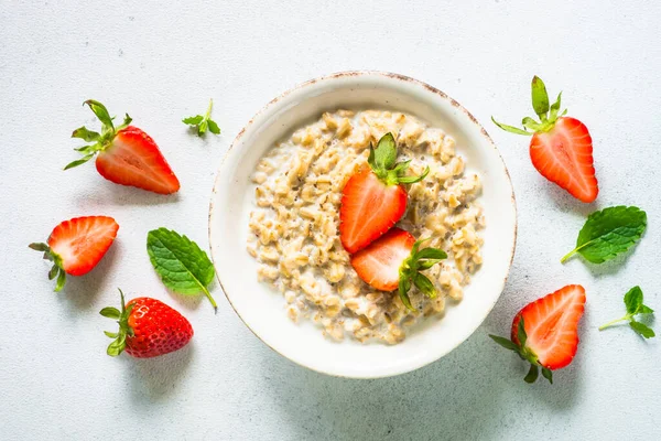 Beyaz arka planda çilekli yulaf lapası..