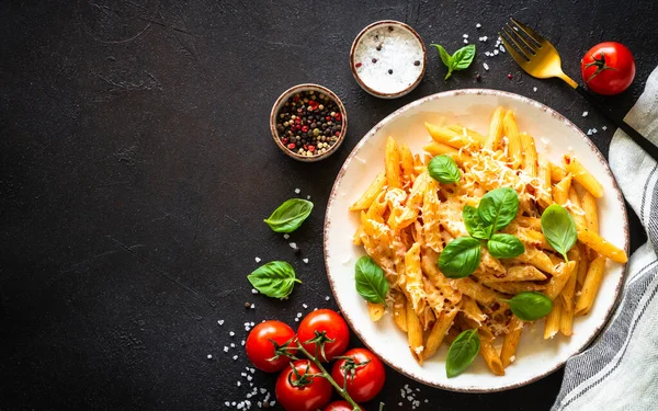 Italian pasta with tomato sauce, basil and parmesan cheese on dark table. — Foto de Stock