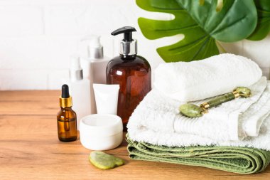 Bir şişe sabun ve beyaz banyoda bir yığın havlu..