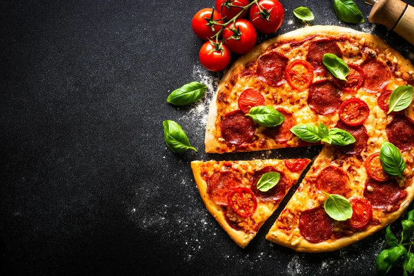 Traditionele Italiaanse pizza met salami kaas, tomaten en basilicum. — Stockfoto