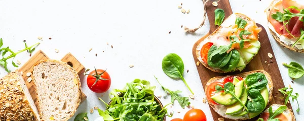 Yemekler için malzemeli sandviç seti. Beyaz masadaki en iyi manzara. Uzun pankart biçimi.