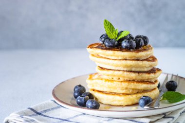 Beyaz masada taze yaban mersinli krep ve bal..