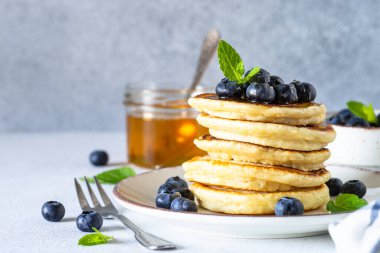 Beyaz masada taze yaban mersinli krep ve bal..