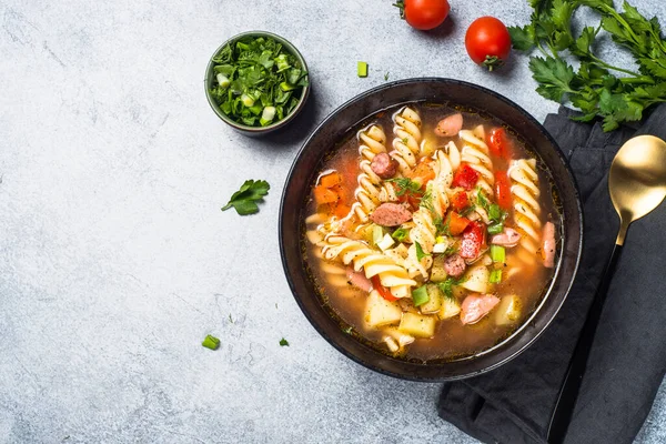 Makarna ve sosisli sebze çorbası. Işık taşı tablosunda kopyalama alanı olan üst görünüm.