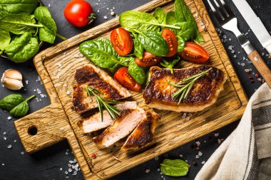 Tahta tahtada servis edilen taze salatalı et biftekleri. Izgara et, bbq. Siyah tabloda en üstteki resim.