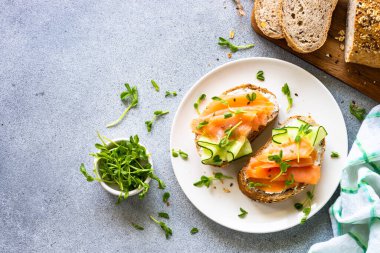 Krem peynirli, somonlu ve salatalıklı sandviç. Sağlıklı kahvaltı ya da atıştırmalık. Kopyalama alanı olan üst görünüm.