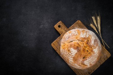 Siyah masada tahıl unlu taze ekmek. En üst görüntü.