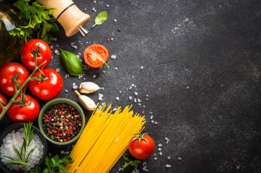Siyahların İtalyan yemekleri geçmişi. Makarna, zeytinyağı, baharat, fesleğen ve taze domates. Kopyalama alanı olan üst görünüm.