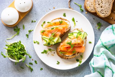 Krem peynirli, somonlu ve salatalıklı sandviç. Sağlıklı kahvaltı ya da atıştırmalık. Üst görünüm.