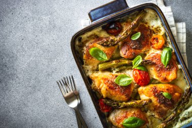 Kuşkonmaz ve soslu domatesli fırında tavuk butları. Makro.