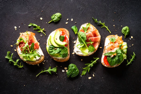 Open Sandwiches Set Cream Cheese Prosciutto Salmon Avocado Fresh Greens — стоковое фото