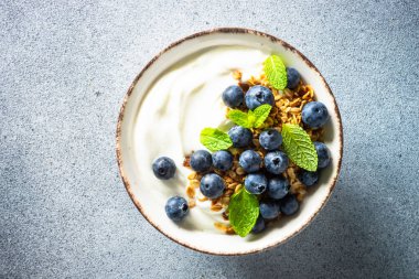 Tahıllı yoğurt ve naneli taze yaban mersini. Sağlıklı kahvaltı. Üst görünüm.