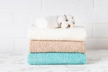 Bir yığın temiz banyo havlusu. Çamaşırhanede ya da banyoda temiz renkli havlular. Beyaz arkaplan.