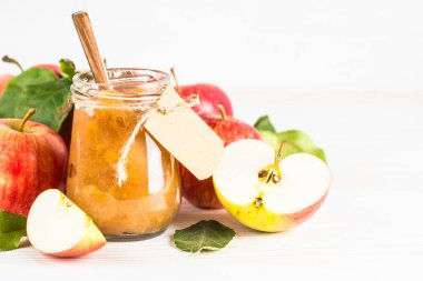 Baharatlı elma reçeli ve beyaz arkaplanda taze elma.