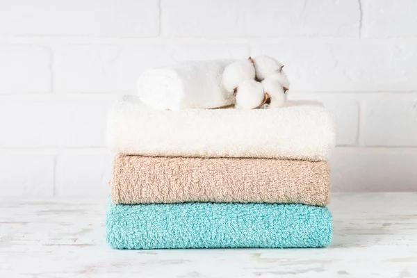 Bir yığın temiz banyo havlusu. Çamaşırhanede ya da banyoda temiz renkli havlular. Beyaz arkaplan.